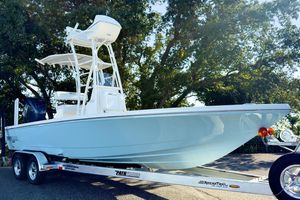 Pathfinder 2500 Hybrid 2026 Pathfinder 2500 Hybrid boat on trailer, parked under trees.