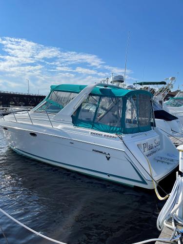 Formula 34 PC 1997 Formula 34 PC boat docked with teal canopy under clear blue sky.