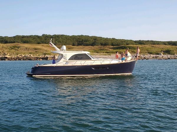 Mochi Craft 44 Dolphin 2007 Mochi Craft 44 Dolphin yacht cruising on calm waters near a scenic coastline.