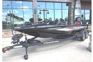 Tracker Savage 215 2025 Tracker Savage 215 boat displayed outside a building with large windows.