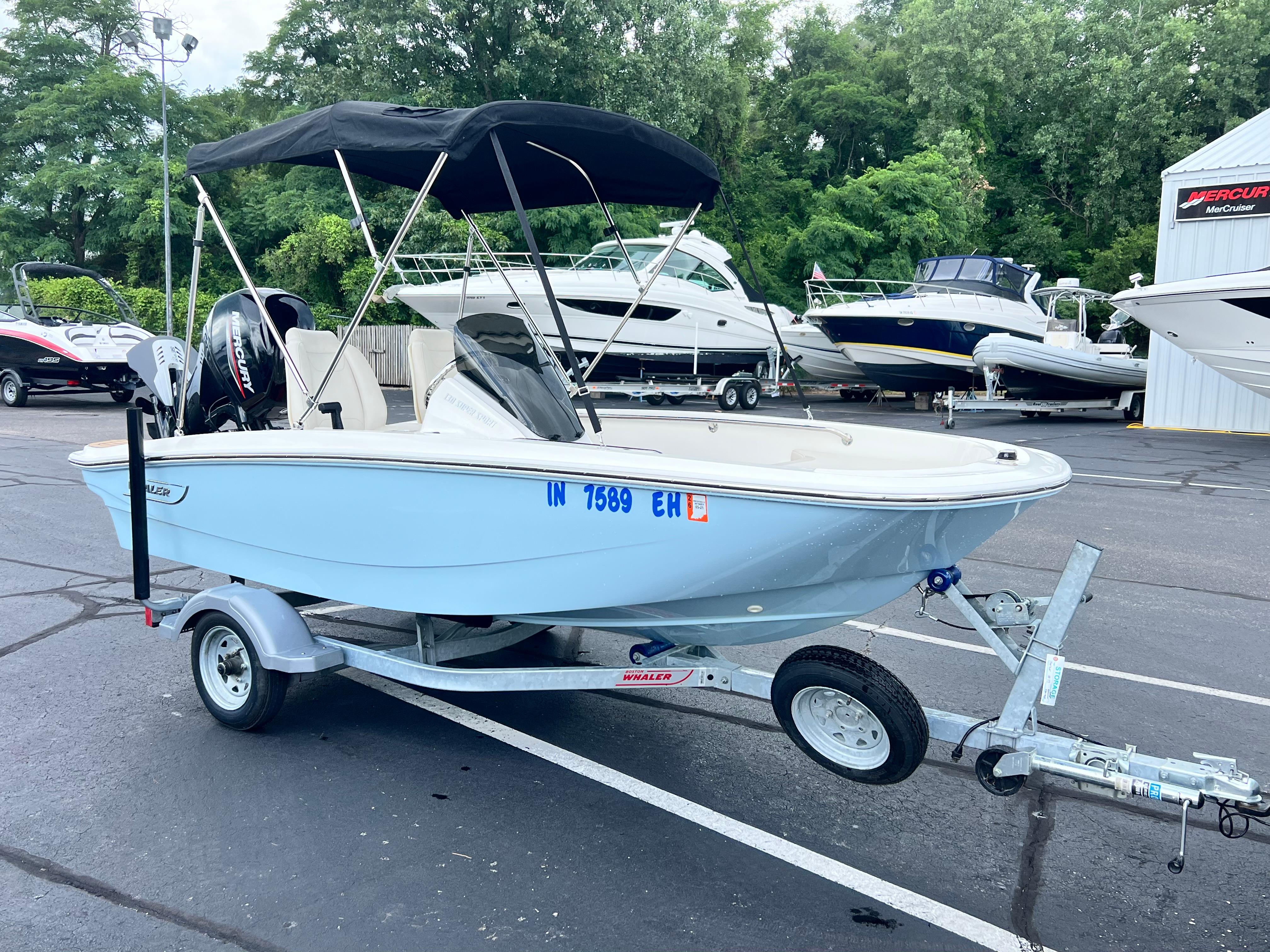Boston Whaler 130 Super Sport 2022 Boston Whaler 130 Super Sport boat on trailer, parked in marina lot.