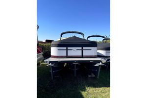 Qwest 824 E-Class RLS Triple Tube LTZ 2023 Qwest 824 E-Class RLS Triple Tube LTZ pontoon boat on grass under clear sky.