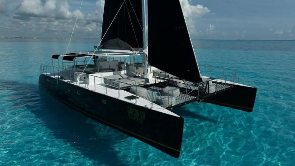 Custom Contoy70 Luxurious 2024 Custom Contoy70 catamaran sailing on clear turquoise waters.