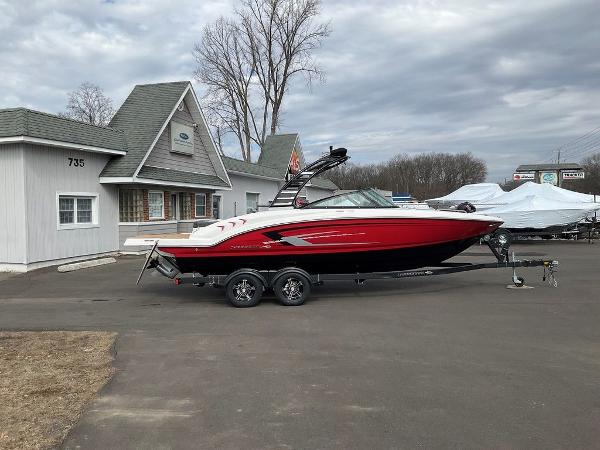 Chaparral 23 SSi 2025 Chaparral 23 SSi boat on trailer, parked outside a building.