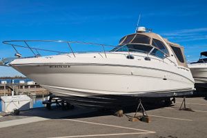 Sea Ray 320 Sundancer 2004 Sea Ray 320 Sundancer boat on stands at a marina under clear blue sky.