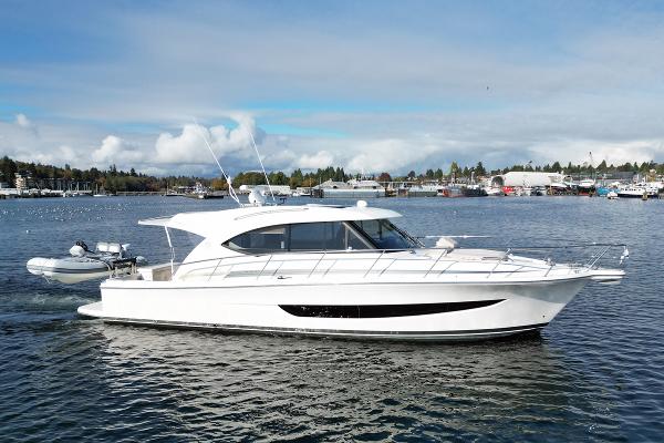 Riviera 395 SUV 2019 Riviera 395 SUV yacht cruising on a calm lake under a clear sky.
