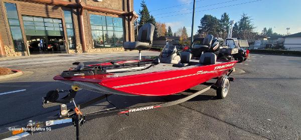 Tracker Pro 170 2024 Tracker Pro 170 boat in vibrant red on a trailer, parked outdoors.