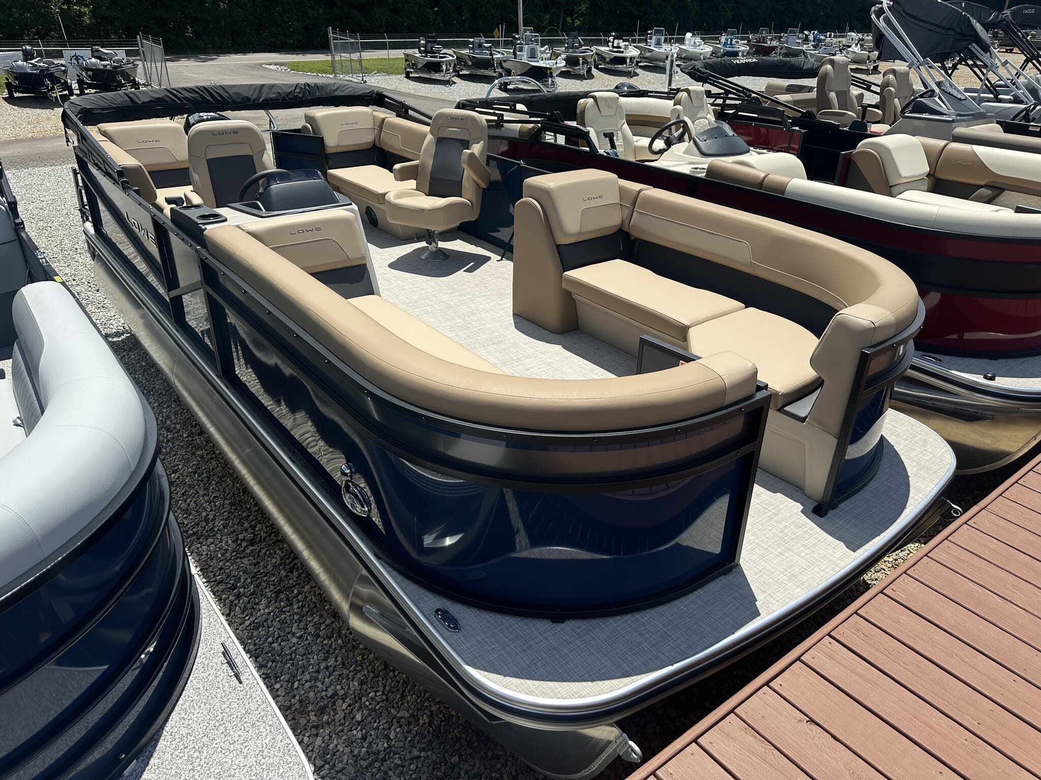 Lowe LS 210 2025 Lowe LS 210 pontoon boat with beige seating, docked in a marina.