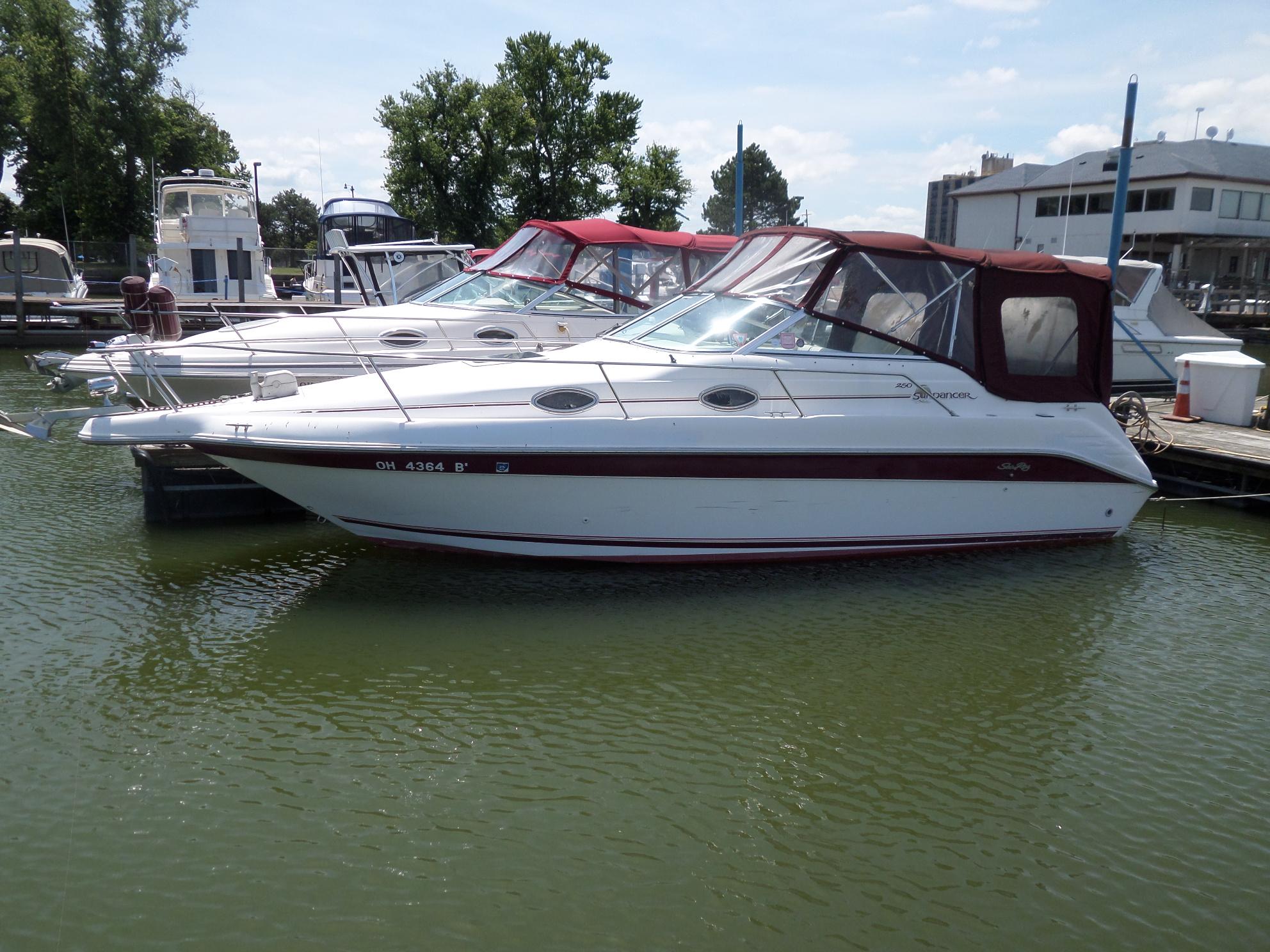 Sea Ray 250 Sundancer 1995 Sea Ray 250 Sundancer docked at marina, featuring maroon canopy and sleek design.