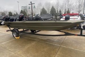 Tracker Grizzly 1860 Utility 2026 Tracker Grizzly 1860 Utility boat on trailer, displayed outdoors on a rainy day.