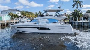 Prestige 520 Flybridge 2021 Prestige 520 Flybridge yacht cruising near waterfront homes and palm trees.
