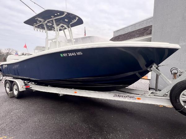 Yellowfin 26 Hybrid 2021 Yellowfin 26 Hybrid boat on trailer, blue hull, parked outdoors.