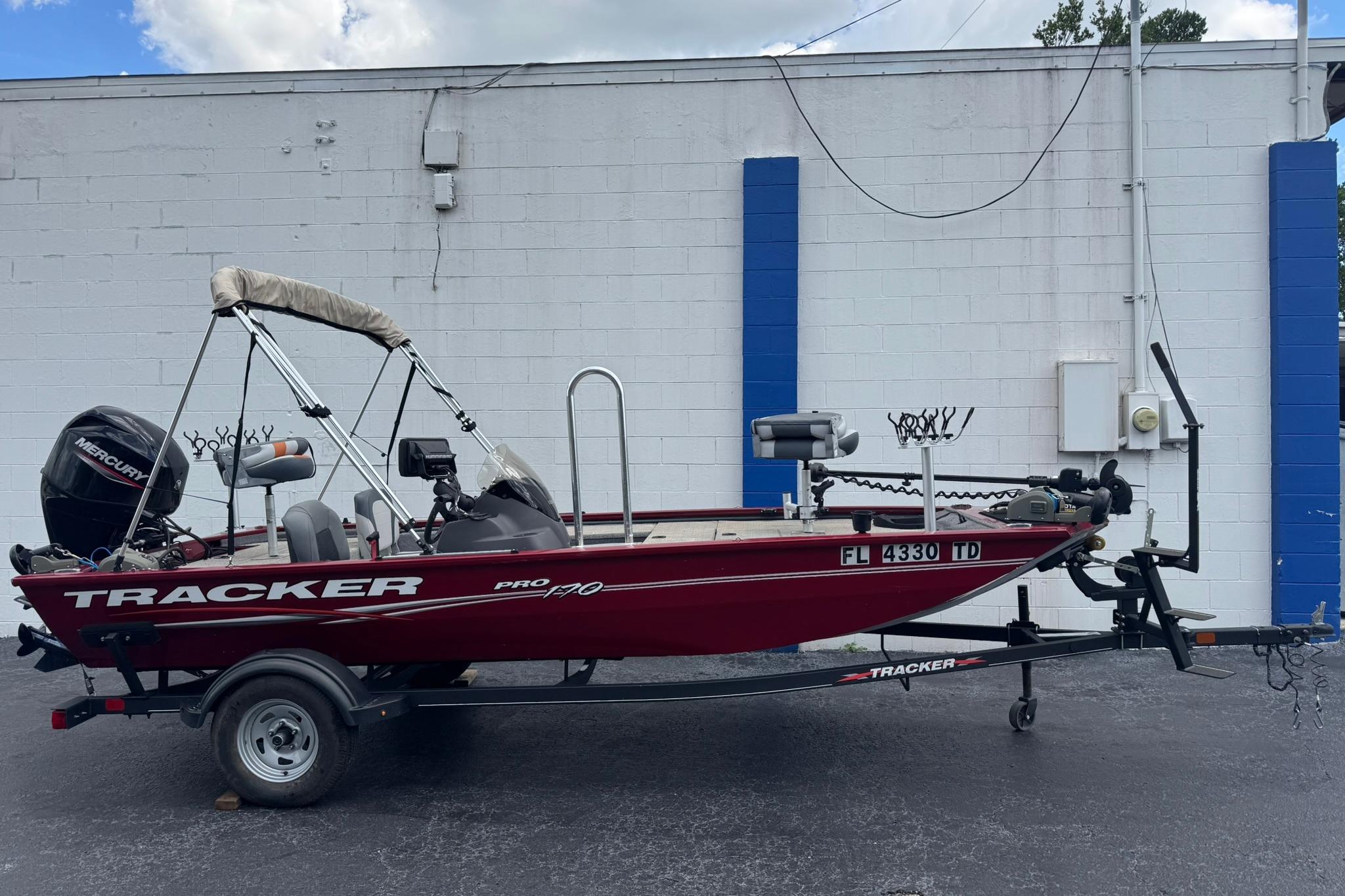 Tracker Pro 170 2022 Tracker Pro 170 boat on trailer, parked against a white and blue wall.