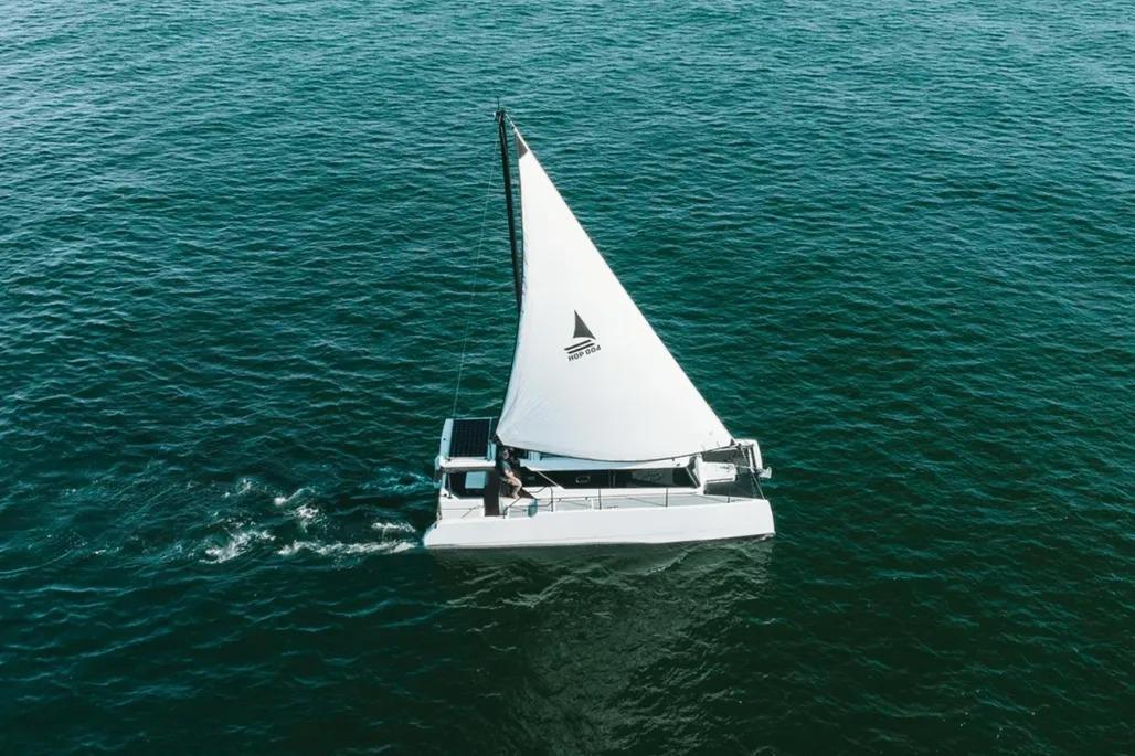 HopYacht 30 Sailing on open water, 2023 Hop Yacht 30 with white sail and sleek design.