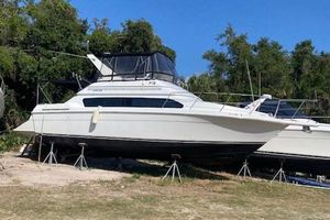 Carver 380 Santego 1998 Carver 380 Santego yacht on stands, surrounded by trees, under clear blue sky.