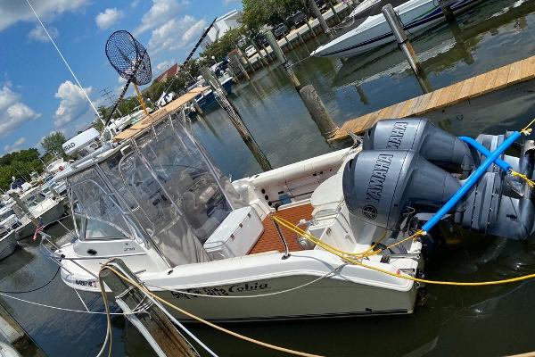 Cobia 270 Walk-Around 2004 Cobia 270 Walk-Around boat docked with Yamaha engines, clear skies, and marina background.