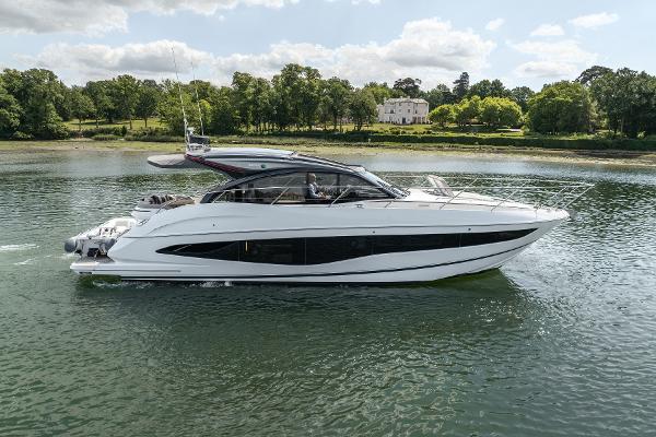 Princess V50 2023 Princess V50 yacht cruising on a serene lake with lush greenery in the background.