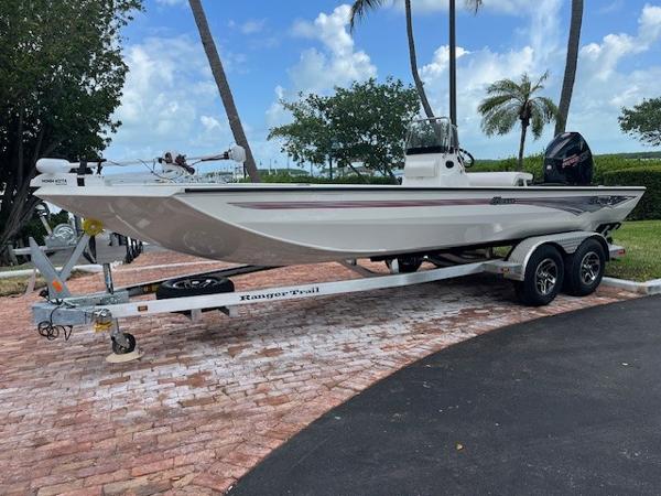Ranger RB210 2025 Ranger RB210 boat on trailer, parked outdoors with palm trees and blue sky.