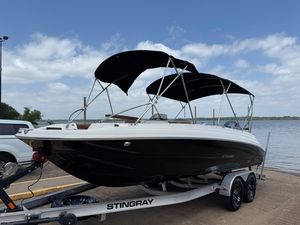 Stingray 212 SC 2022 Stingray 212 SC boat on trailer by the water, featuring black hull and canopy.