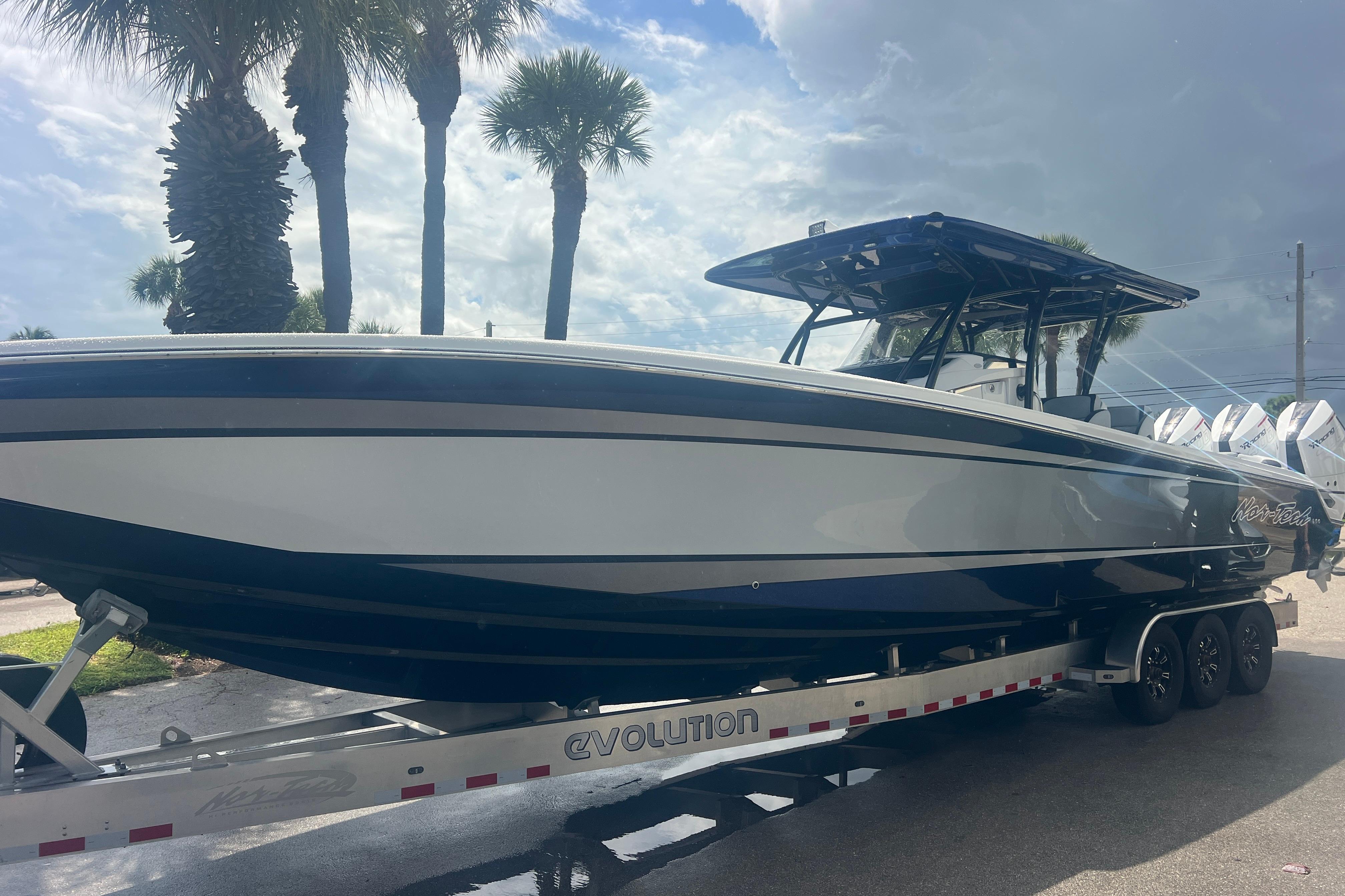 Nor-Tech 390 Sport Center Console 2026 Nor-Tech 390 Sport Center Console boat on trailer, parked under palm trees.