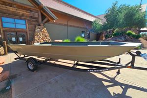 Tracker Grizzly 2072 Utility 2026 Tracker Grizzly 2072 Utility boat on trailer outside rustic building.