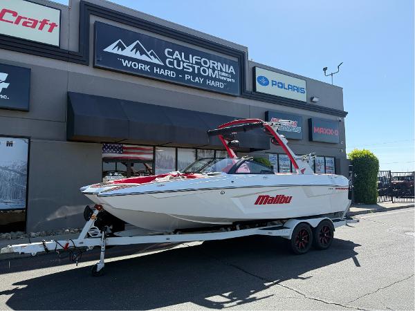 Malibu Wakesetter 23 MXZ 2023 Malibu Wakesetter 23 MXZ boat on trailer outside California Custom store.