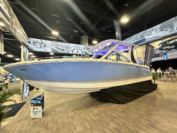 Chaparral 310 OSX 2025 Chaparral 310 OSX boat displayed at an indoor exhibition, showcasing sleek design and modern features.