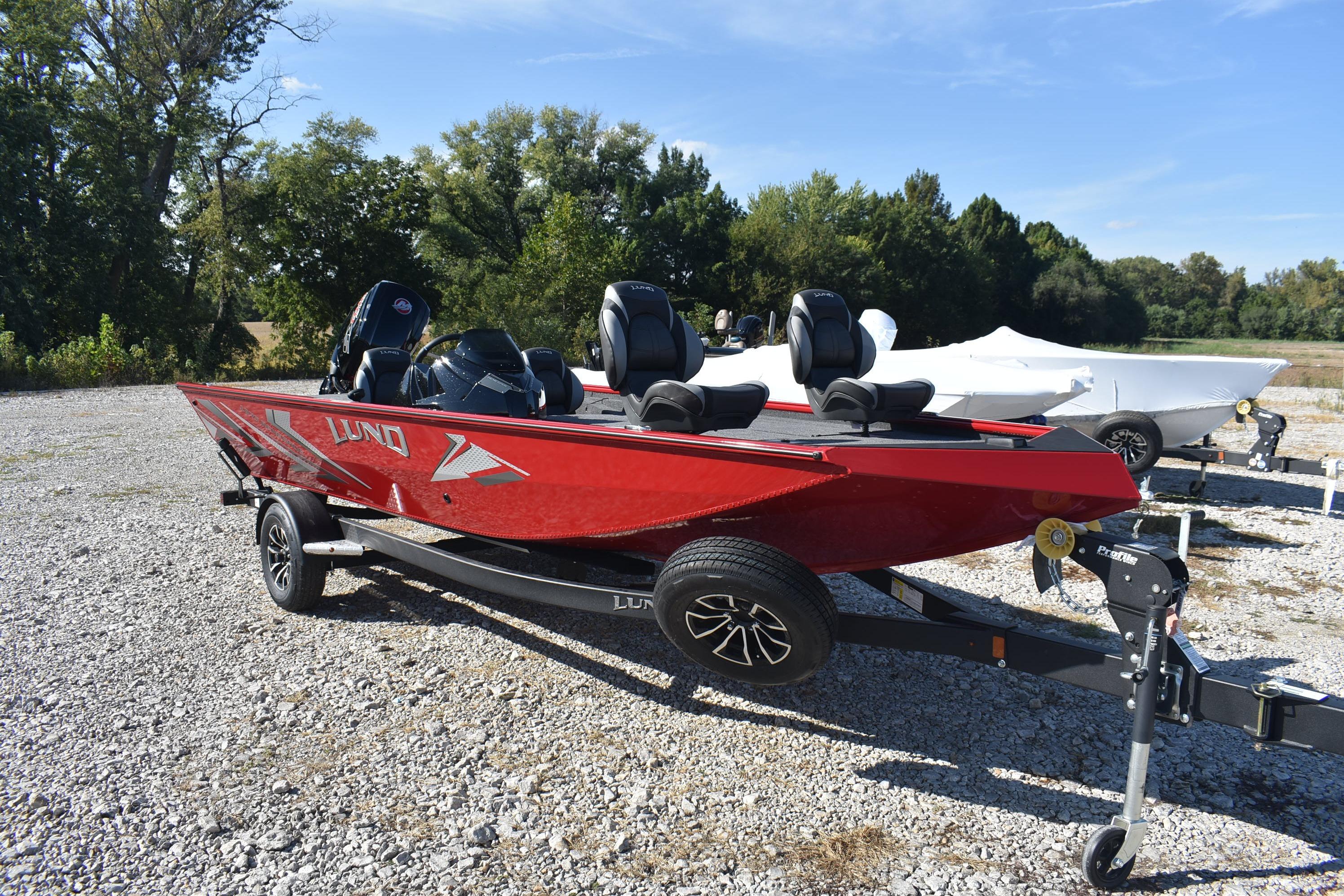 Lund 1875 Renegade 2026 Lund 1875 Renegade boat in vibrant red on a trailer, parked outdoors.