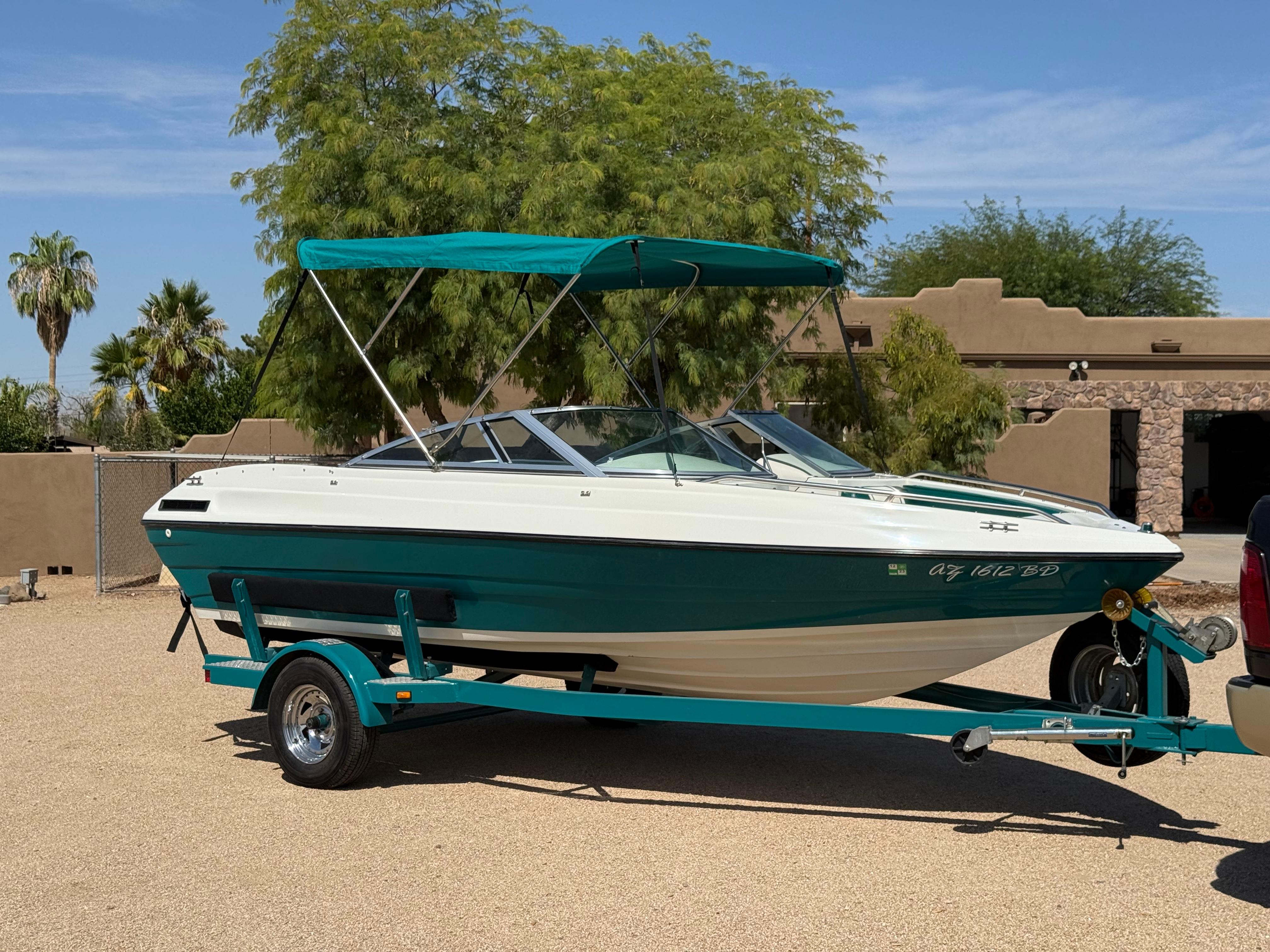 Mariah Talari 182 1995 Mariah Talari 182 boat on trailer with teal canopy, parked outdoors.