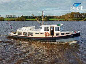 Custom Hamburger Barkas Custom 1926 Hamburger Barkas boat "HEDI" cruising on a scenic river, Smelne Yachtcenter logo visible.