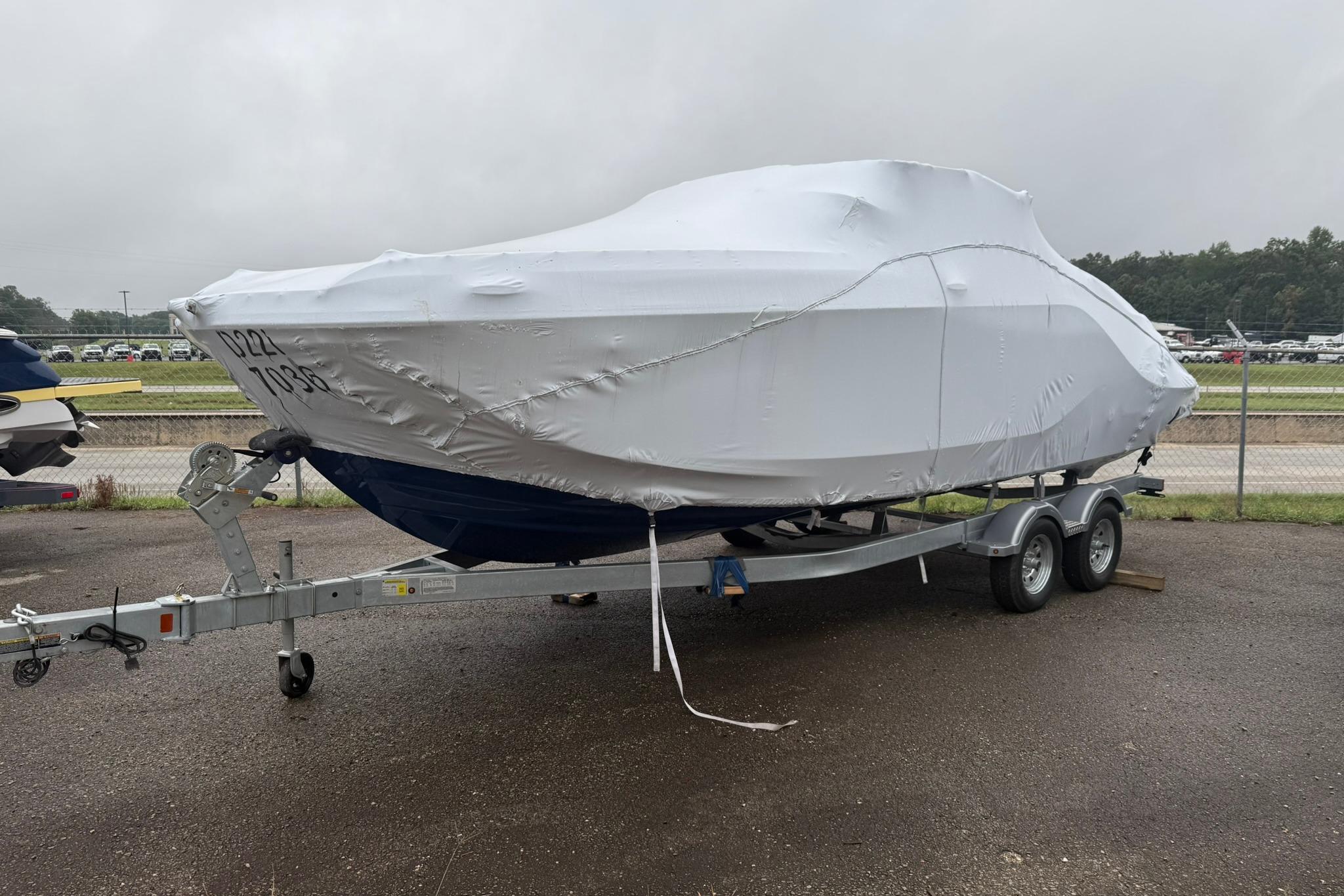 Bayliner D22I 2025 Bayliner D22I boat covered on a trailer in a parking lot.