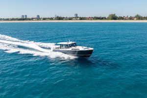 MJM 42 2025 MJM 42 boat cruising on clear blue ocean near coastline.