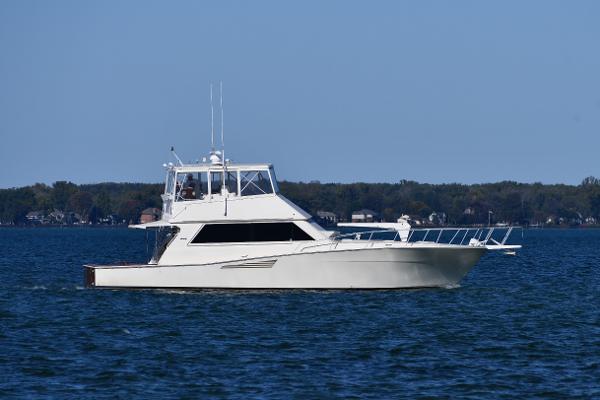 Viking 53 Convertible 1990 Viking 53 Convertible yacht cruising on a calm lake with distant shoreline.