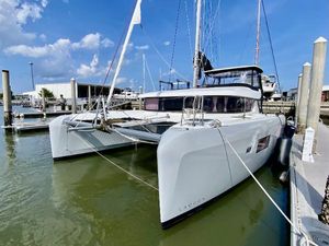 Lagoon 42 Owners Version 2019 Lagoon 42 Owners Version catamaran docked at marina under blue sky.