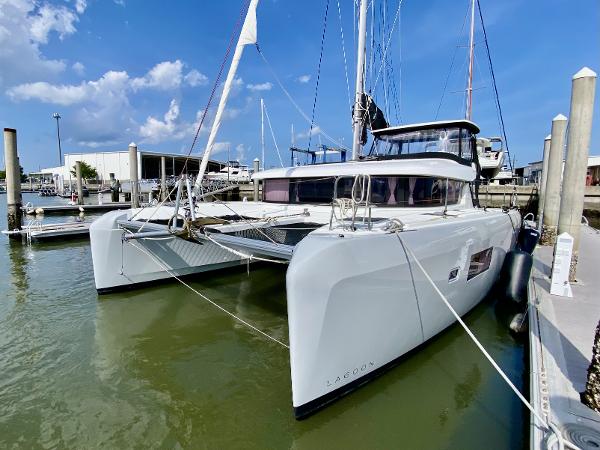 Lagoon 42 Owners Version 2019 Lagoon 42 Owners Version catamaran docked at marina under blue sky.