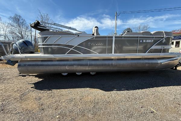 Sylvan L Series L-3 LZ 2022 Sylvan L Series L-3 LZ pontoon boat on gravel, side view.