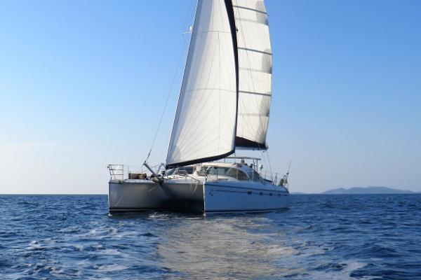 Privilege 435 Sailing catamaran Privilege 435, 2006 model, cruising on open sea under clear blue sky.