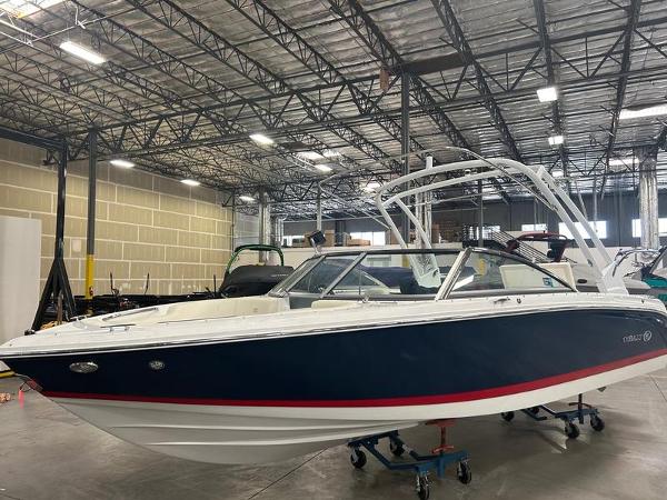 Cobalt 220S 2022 Cobalt 220S boat in a warehouse, featuring a sleek blue and white design.
