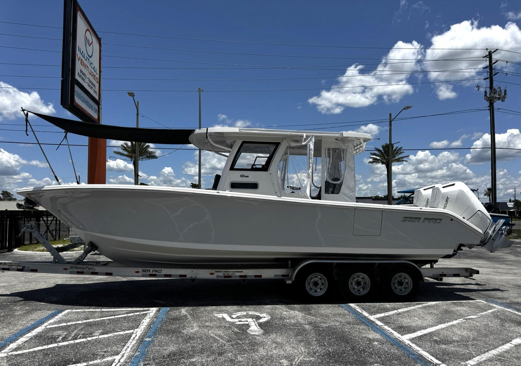 Sea Pro 322 DLX 2024 Sea Pro 322 DLX boat on trailer under clear blue sky.