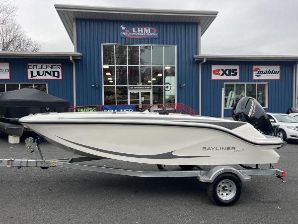Bayliner M17 2024 Bayliner M17 boat on a trailer outside a dealership.