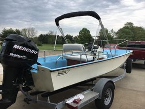 Boston Whaler Nauset 1967 Boston Whaler Nauset boat on trailer with Mercury engine, parked outdoors.
