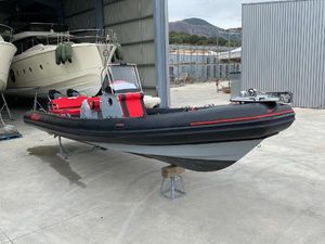 Marshall M8 TOURING 2022 Marshall M8 TOURING boat in storage, featuring sleek black and red design.