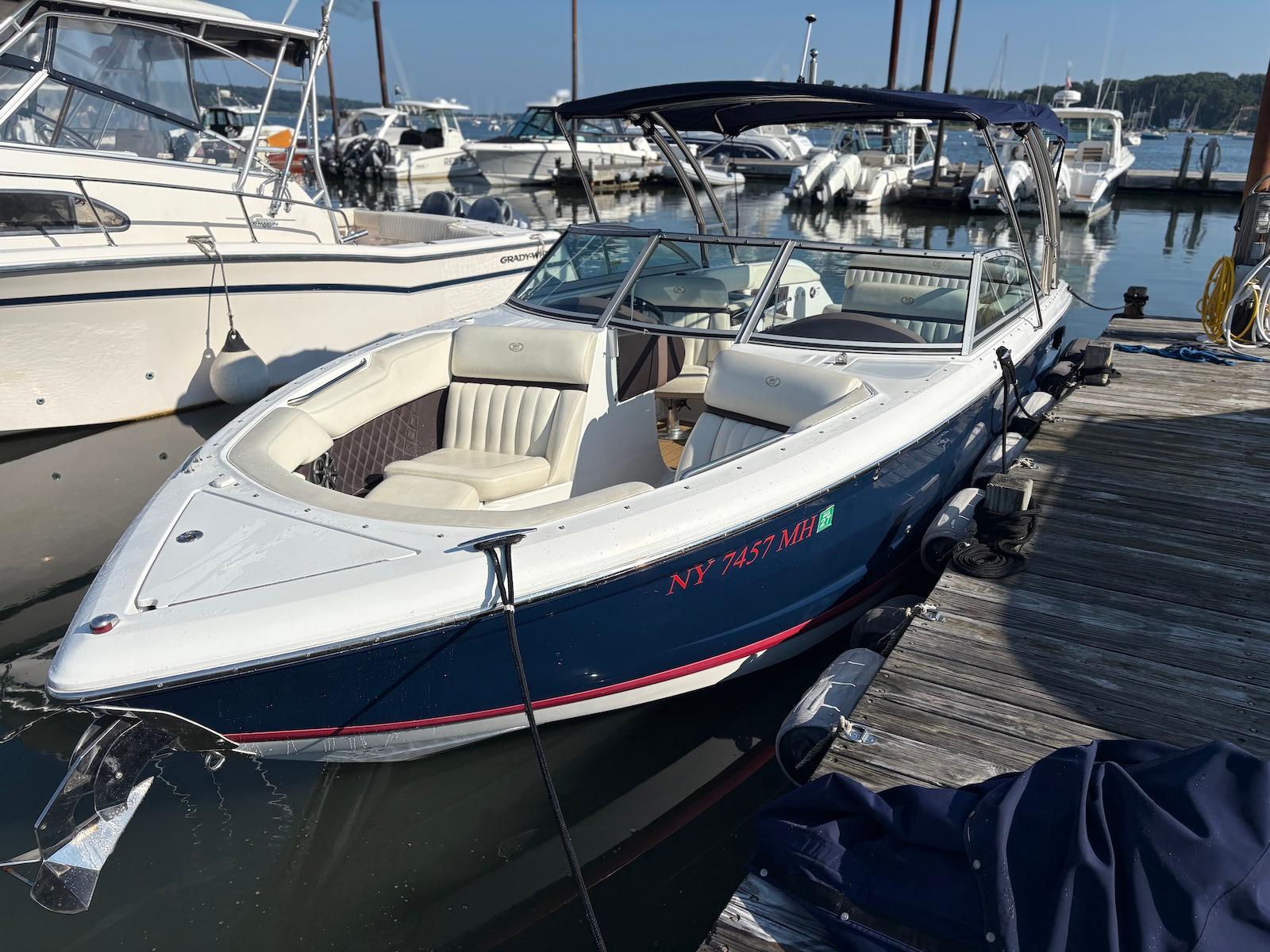 Cobalt A28 2012 Cobalt A28 boat docked at marina, featuring sleek design and comfortable seating.