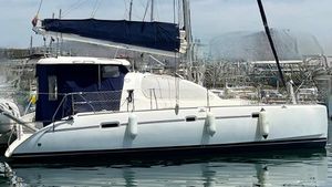 Leopard 40 2006 Leopard 40 catamaran docked in marina, featuring sleek design and blue sail cover.