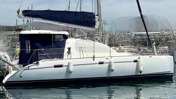 Leopard 40 2006 Leopard 40 catamaran docked in marina, featuring sleek design and blue sail cover.