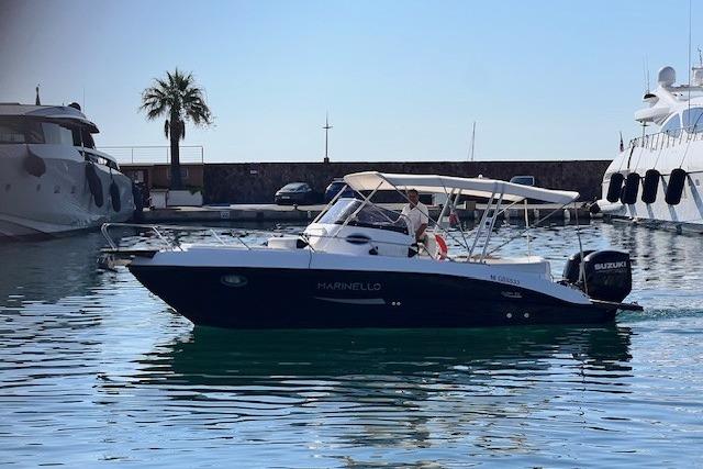 Marinello 26' cabin 2024 Marinello 26' cabin boat cruising in a marina, featuring a sleek design and Suzuki outboard.