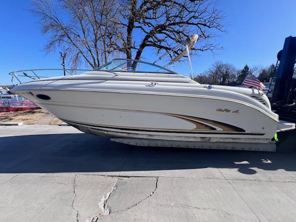 Sea Ray 245 Weekender 2000 Sea Ray 245 Weekender boat on trailer, parked outdoors under clear blue sky.