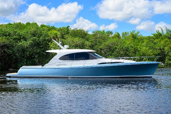 Palm Beach Motor Yachts GT50 2024 Palm Beach Motor Yachts GT50 on serene water, lush greenery background.