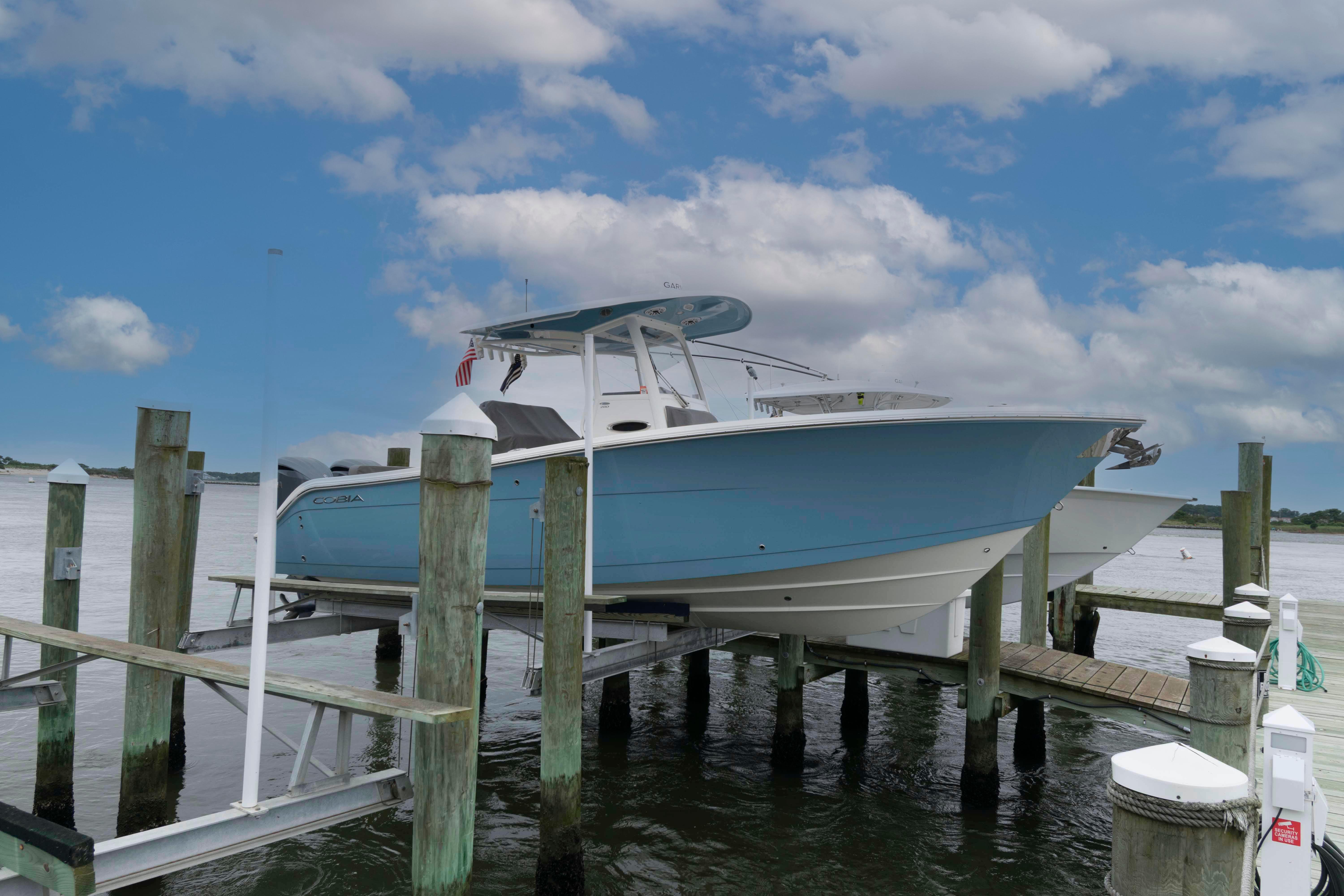 Cobia 280 Center Console 2023 Cobia 280 Center Console boat docked under a cloudy sky.