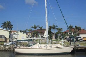 Island Packet 380 1999 Island Packet 380 sailboat docked near palm trees and houses.